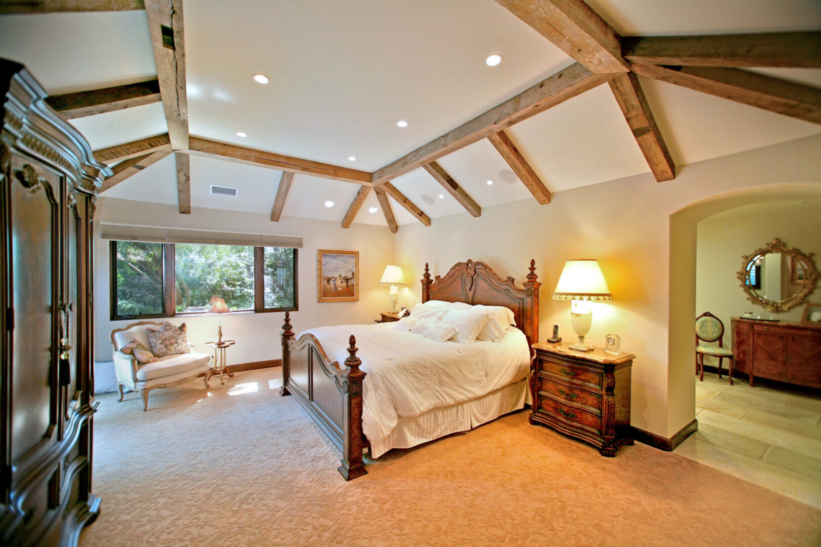 A bedroom with a bed, chair and night stand.