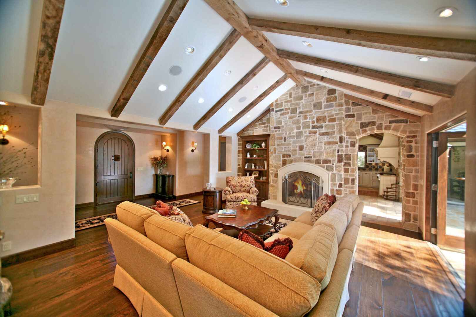 A living room with a fireplace and vaulted ceiling.