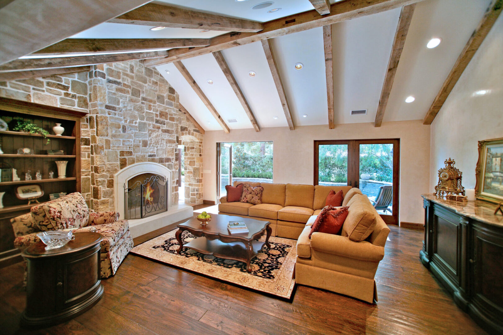 A living room with wood floors and stone fireplace.