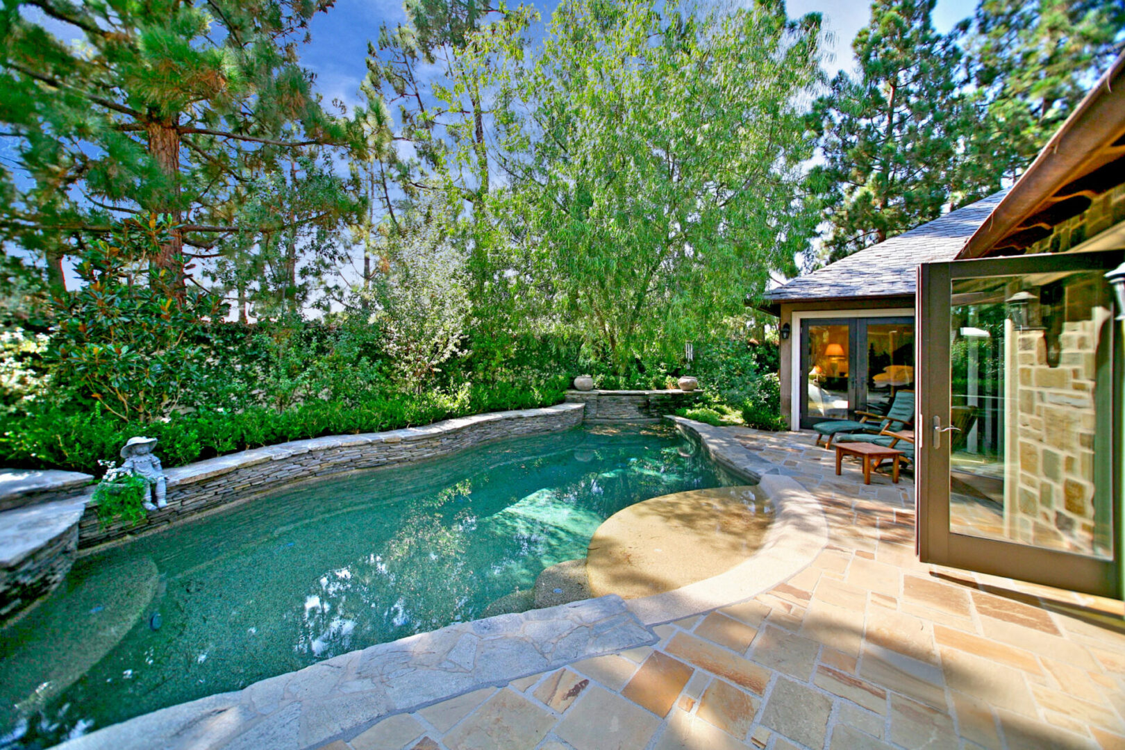 A pool with a gazebo and patio furniture.