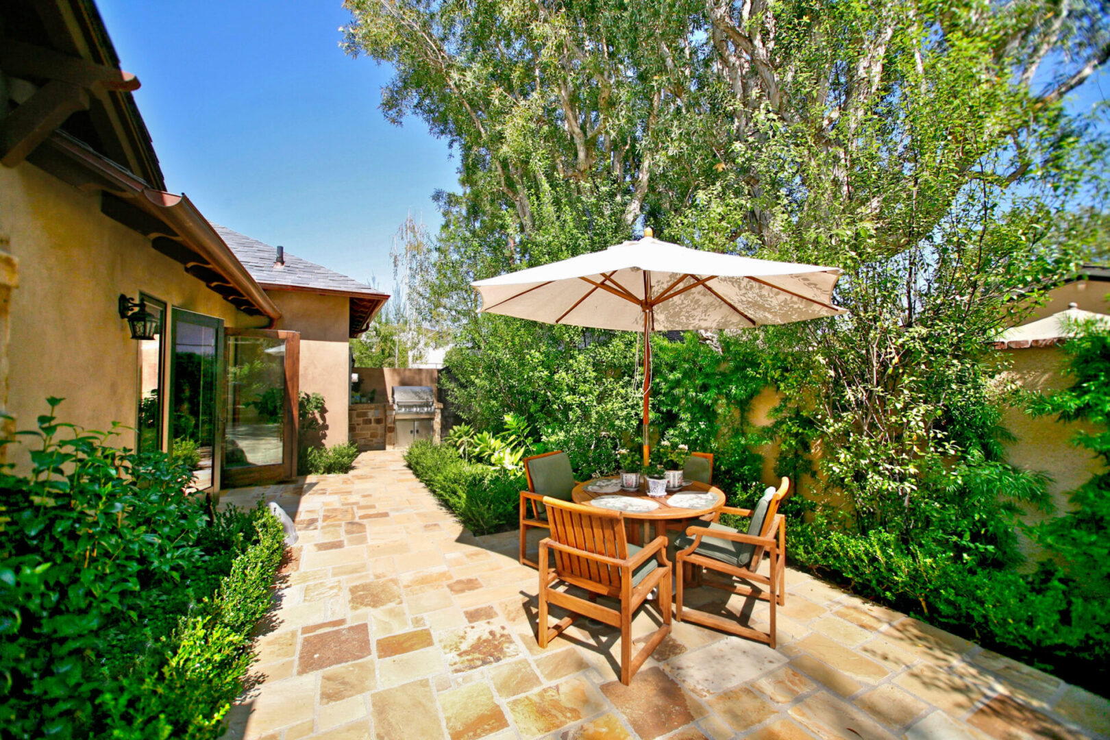 A patio with an umbrella and chairs in it