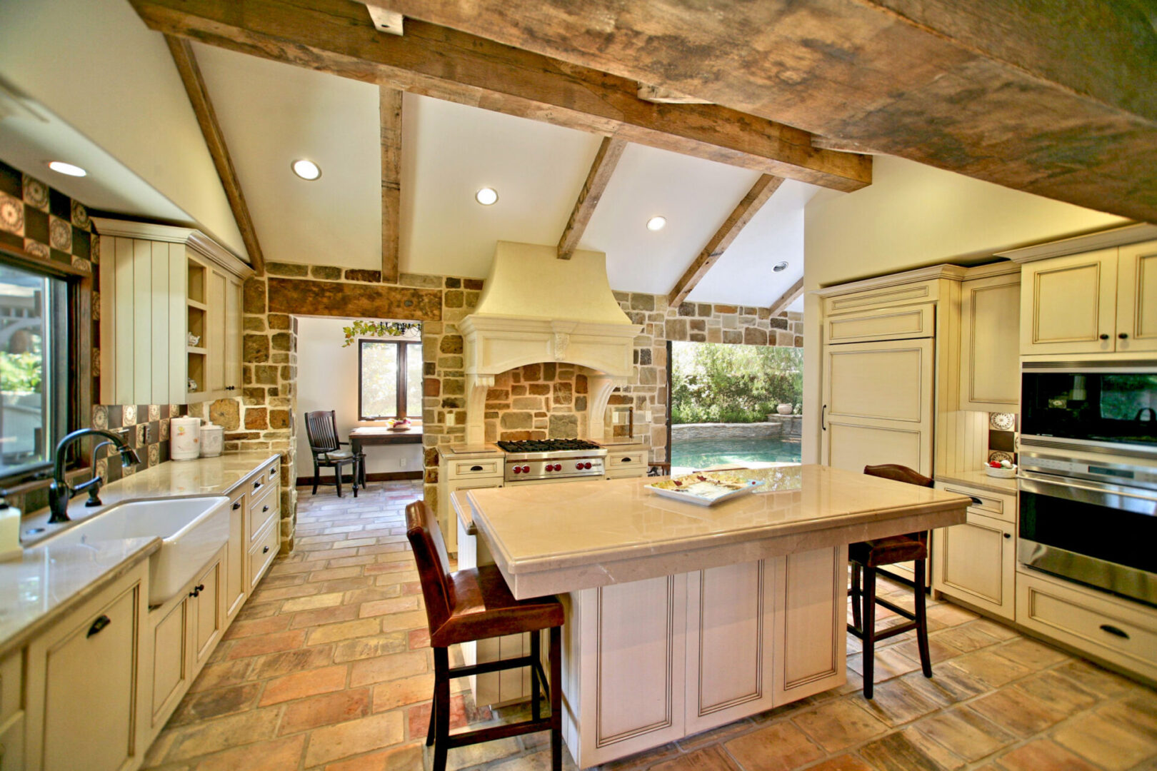 A kitchen with a large island and brick walls.