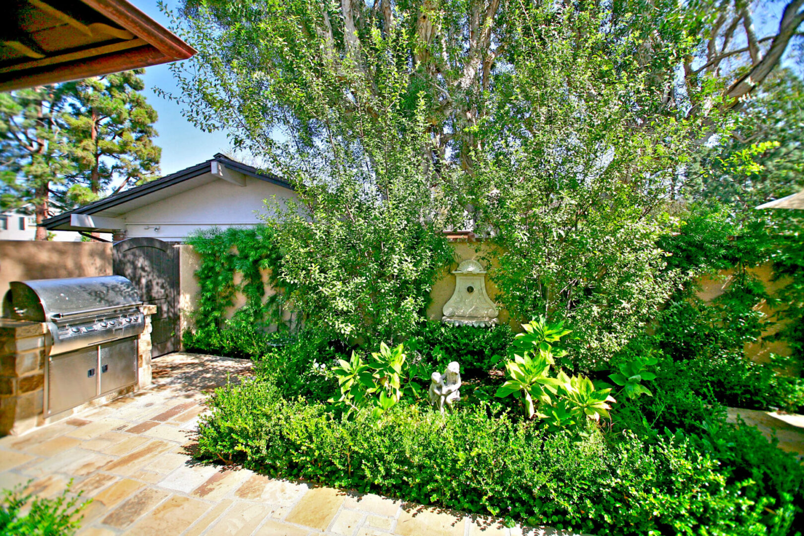 A garden with bushes and trees in the background.