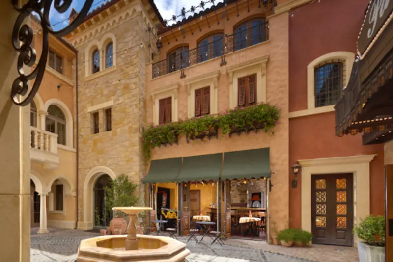 A fountain in front of a building with a green awning.