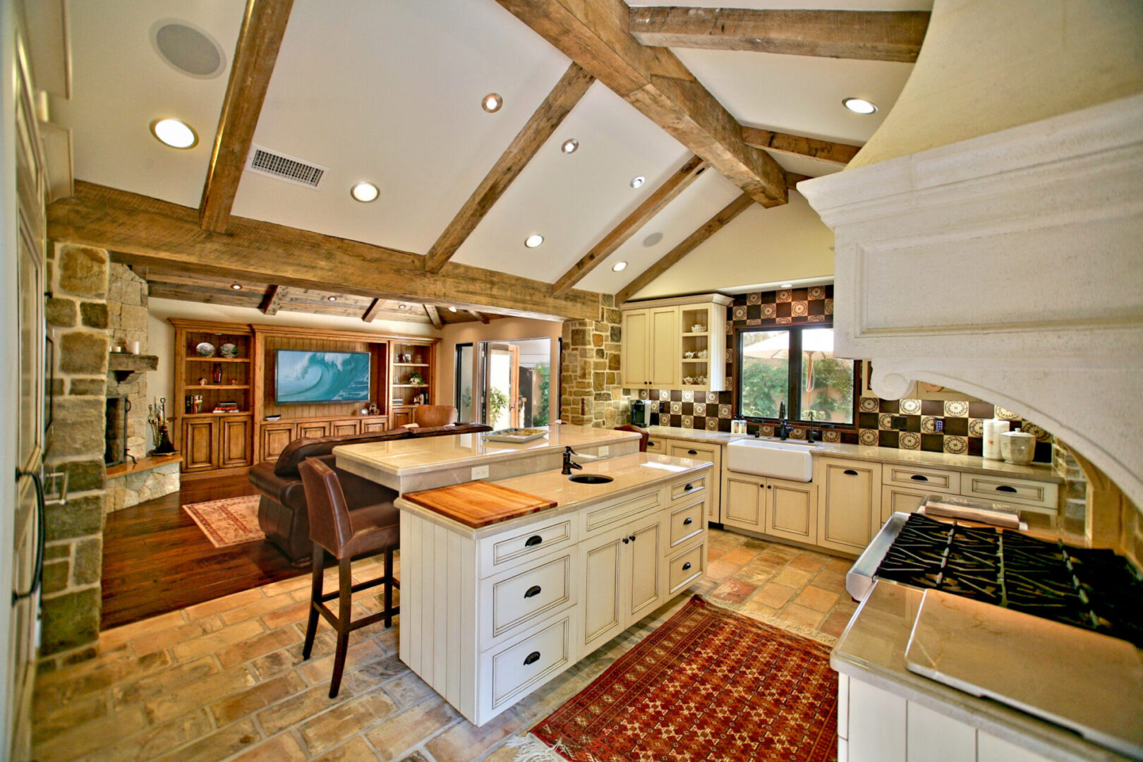 A kitchen with a large island and wooden beams.