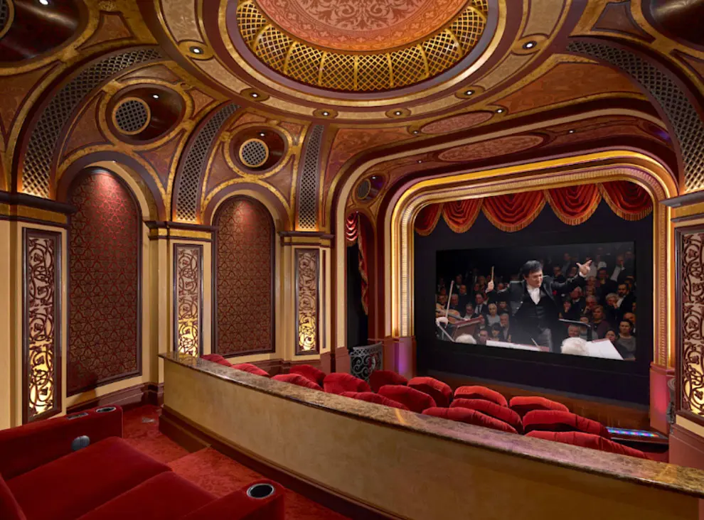 A theater with red seats and a large screen.