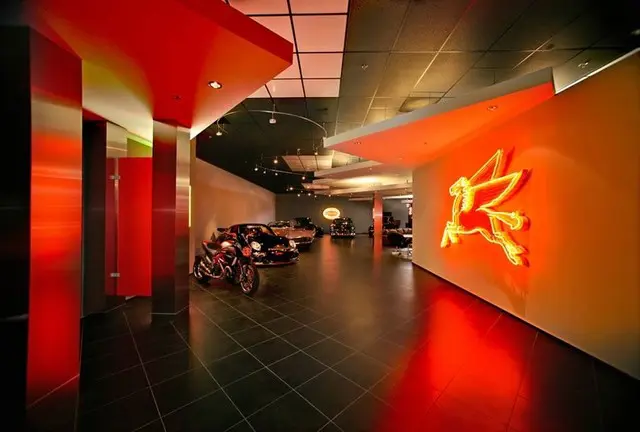 A red room with motorcycles parked in it.