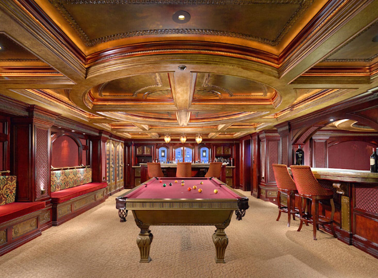 A pool table in the center of a room with many wooden walls.