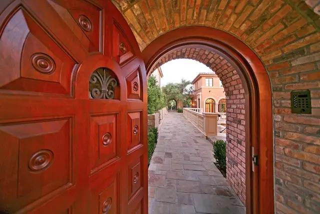 A red door opens to the side of a brick walkway.